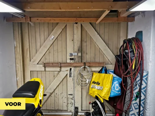 Oude dubbele houten garagedeuren vóór vervanging in een woning in ’s-Hertogenbosch