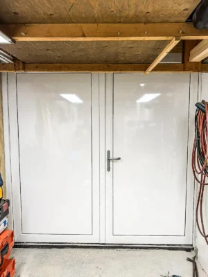 Witte dubbele garagedeuren geplaatst tijdens een renovatieproject in ’s-Hertogenbosch