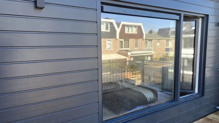 Detail van de moderne Keralit gevelbekleding en groot raam na de complete renovatie van een woning in Amstelveen