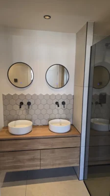 Moderne badkamer na de complete renovatie van een woning in Amstelveen met dubbele wastafel en minimalistische afwerking