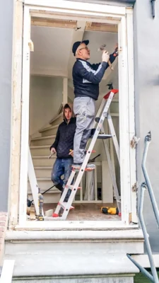 Demontage van oude balkondeuren tijdens vervanging van houten kozijnen in Amsterdam