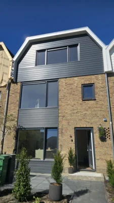 Vooraanzicht van de woning na de complete renovatie in Amstelveen met nieuwe dakopbouw, ramen en Keralit gevelafwerking