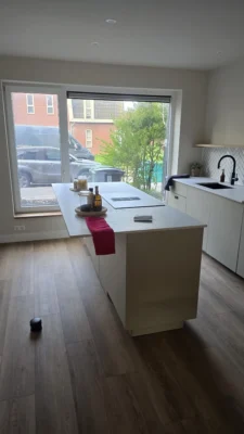 Moderne keukenafwerking na de complete renovatie van een woning in Amstelveen met grote raampartijen en nieuwe schuifdeuren