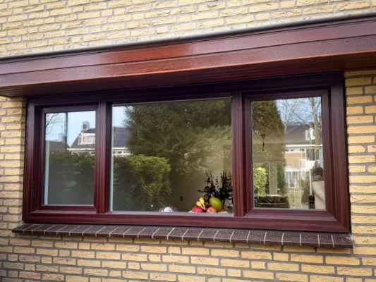 Bruin PVC kozijn met Aluplast 7000 NL aan de voorzijde van een woning in Rijswijk