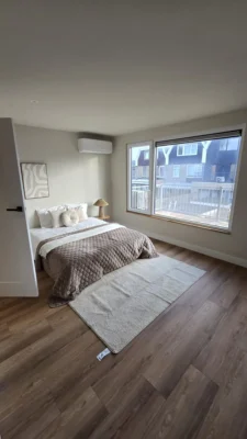 Modern afgewerkte slaapkamer na de complete renovatie van een woning in Amstelveen met grote ramen en een licht interieur