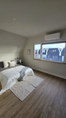 Ruime slaapkamer na de complete renovatie van een woning in Amstelveen met grote ramen en moderne interieurafwerking